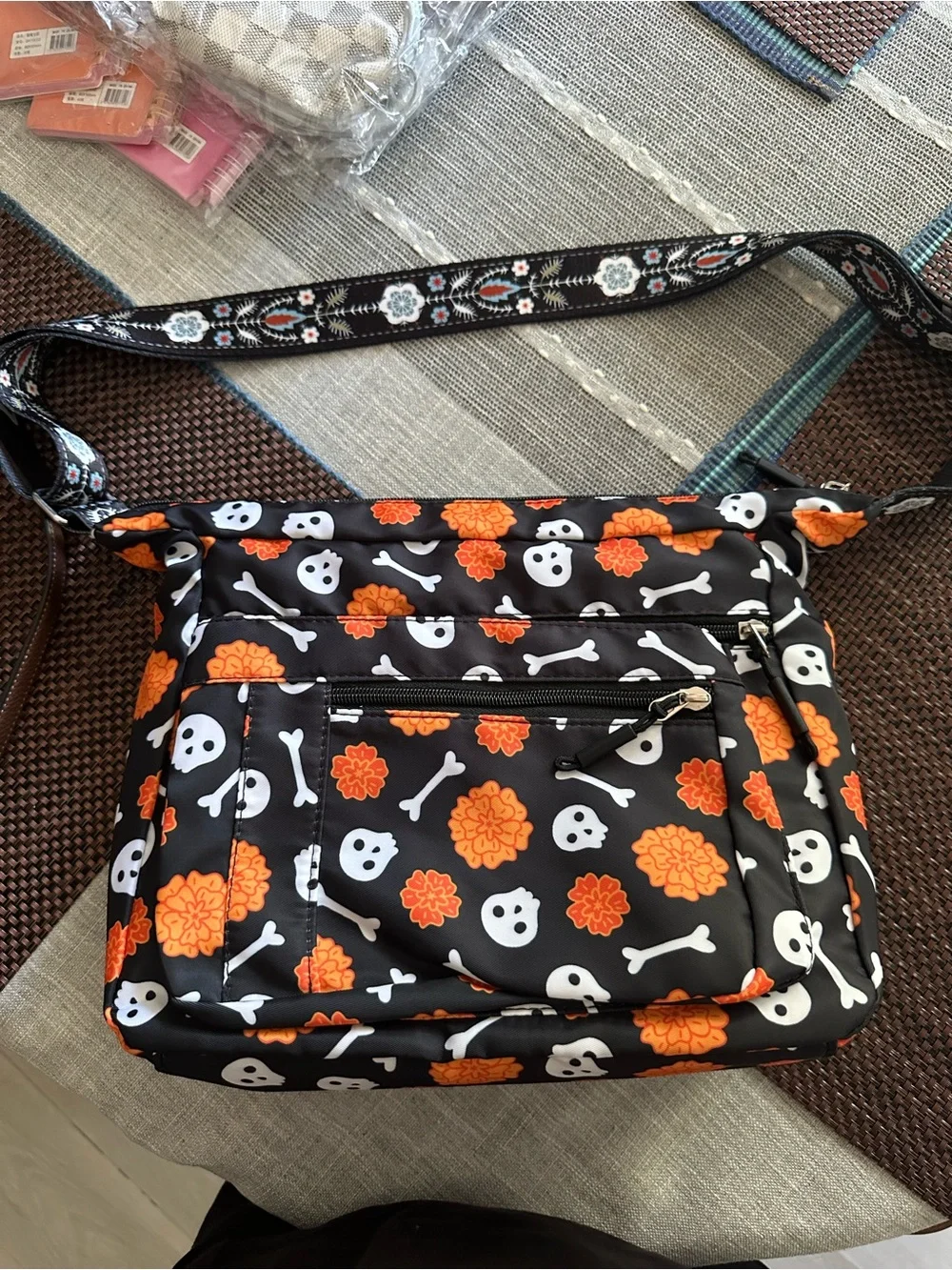 Halloween-themed crossbody bag featuring a skull and marigold print